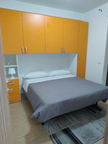 a bedroom with a large bed with yellow cabinets at Petit Appartament in Policoro