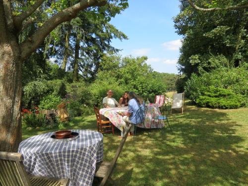 a group of people sitting at a table in the grass at Le Chant Des Fees in Notre-Dame-de-Courson