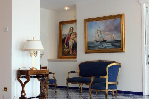 a room with two chairs and a table and a painting at Punta Campanella Resort & Spa in Massa Lubrense