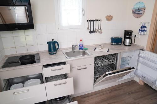 a kitchen with a sink and a dishwasher at Tiny House - Camping am Lippesee in Paderborn