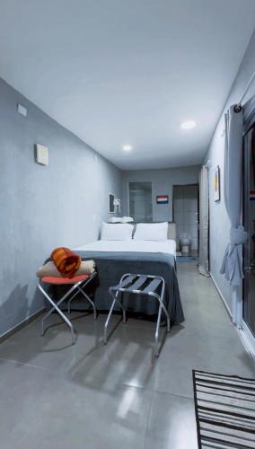 a bedroom with a large bed and two chairs at Amsterdam Lofts Deluxe in Poços de Caldas