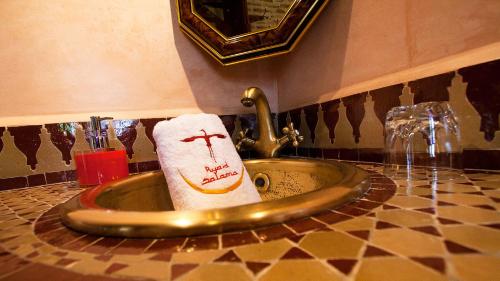 a bathroom sink with a towel and a faucet at Ryad Salama in Fès