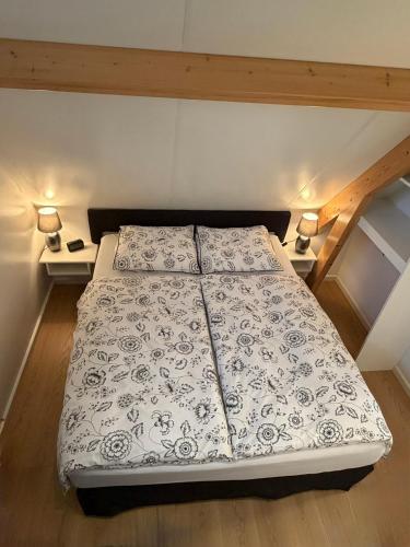 a bed in a small room with two lamps at Top appartement in prachtige hart van Nederland Kortenhoef in Kortenhoef