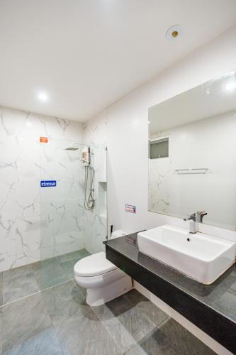 a white bathroom with a sink and a toilet at สายป่าน พลูวิลล่า in Cha Am