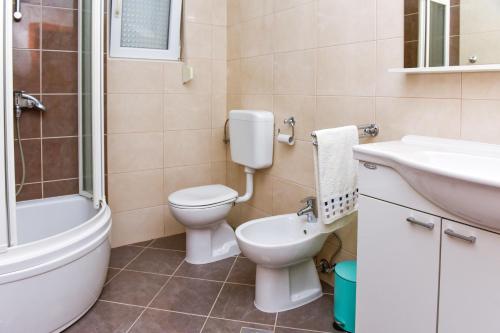 a bathroom with a toilet and a sink and a shower at Apartments Purkovic in Vodice