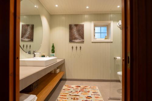 a bathroom with a sink and a toilet and a mirror at Maybua by May's in Reine