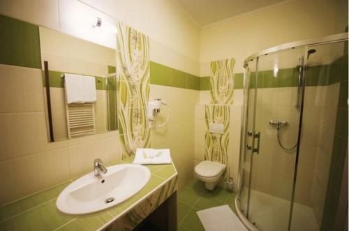 a bathroom with a sink and a shower and a toilet at Wellness hotel Spark in Malacky