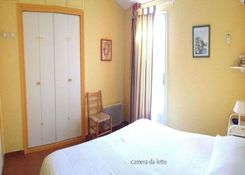 une chambre avec un lit blanc et une fenêtre dans l'établissement Minivilla Marina di Santa Giulia, à Porto-Vecchio