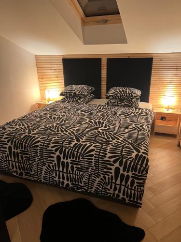 a bedroom with a black and white bed with two pillows at Apartament M6 in Leśna