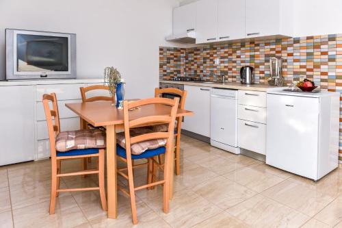 a kitchen with a table and chairs and a tv at Apartments Purkovic in Vodice
