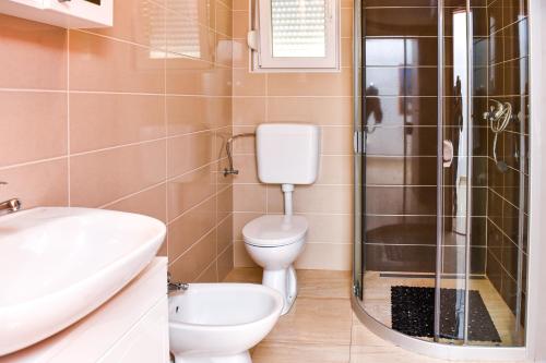 a bathroom with a toilet and a glass shower at Apartments Purkovic in Vodice
