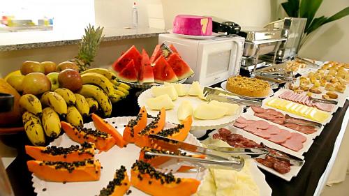 a table topped with lots of different types of food at Apoema Hotel in Cuiabá