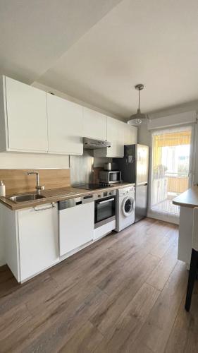 a kitchen with white cabinets and a sink and a stove at Appartement 3P Nice in Nice