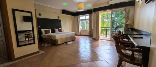 a bedroom with a bed and a large window at Isamilo Grand Hotel in Mwanza
