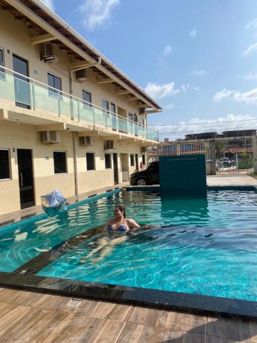 a woman in a swimming pool at a hotel at pousada ondas do atlântico in Salinópolis