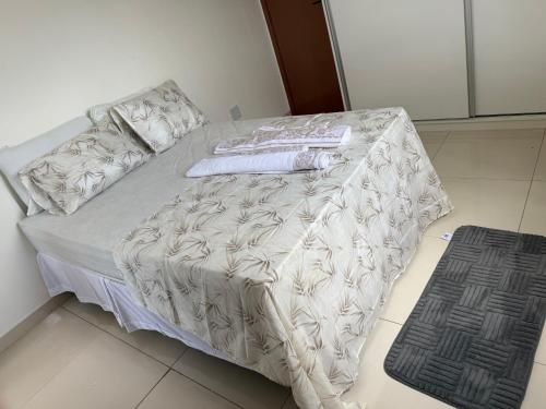 a bed with a white comforter and towels on it at pousada ondas do atlântico in Salinópolis
