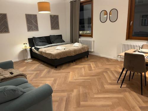 a bedroom with a bed and a table and a couch at Triberg City Apartment 1 in Triberg