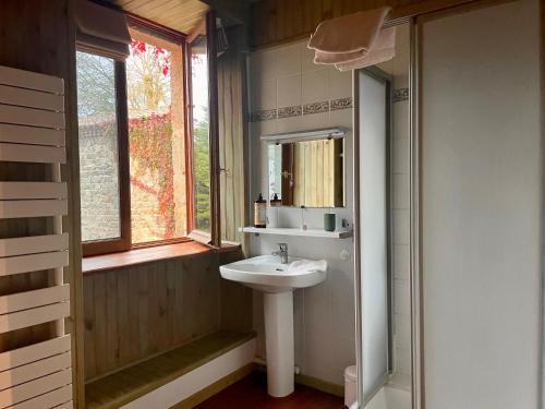 a bathroom with a sink and a window at L'ancien Relais de Poste*** in Saint-Dier-dʼAuvergne