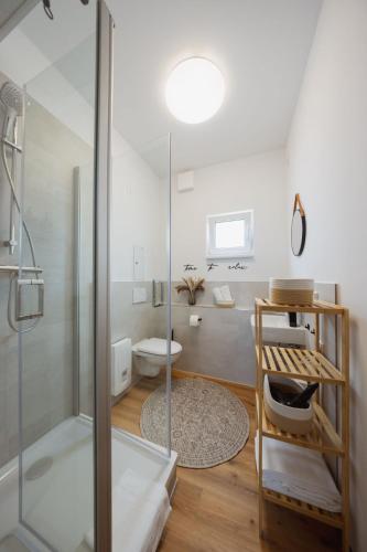 a bathroom with a glass shower and a toilet at HYGGE HOMES Apartment 'Scandi Sunset' in Winsen