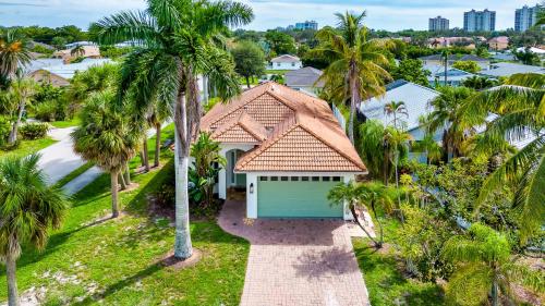 an aerial view of a house with palm trees at Neapolitan Vacation Rentals - Pet Friendly, Newly Updated Luxury Home with Private Pool! Complete Privacy and Only a 10 Minute Walk to Vanderbilt Beach Close to Mercato and the Best of Naples in Naples
