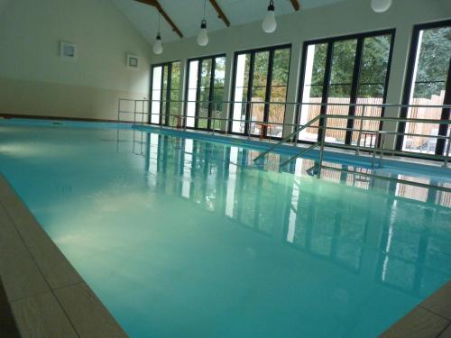a large swimming pool with blue water in a building at Loire & Sens in Juigné-sur-Loire