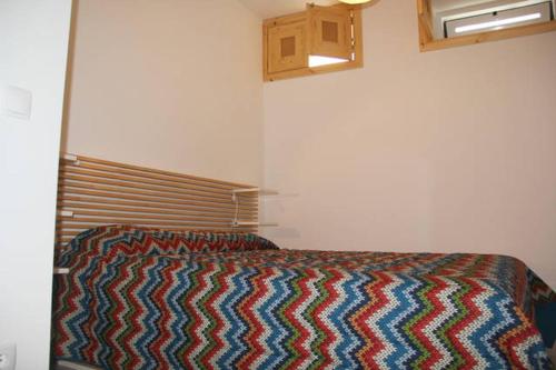 ein Schlafzimmer mit einem Bett mit einer bunten Decke darauf in der Unterkunft Garden Apartment in Lissabon