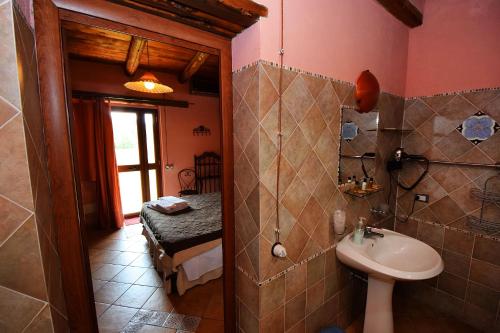 a bathroom with a toilet and a sink in a room at Giucalem La Casa Negli Orti in Piazza Armerina