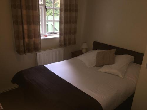 a bedroom with a white bed with a window at The Winchfield Inn in Winchfield
