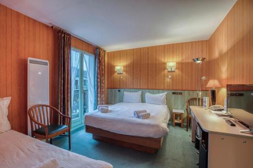 a hotel room with a bed and a desk and a desk at Brit Hotel Florimont in Saint-Ferréol