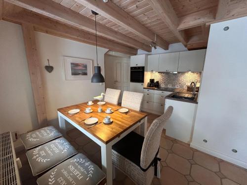 a kitchen and dining room with a wooden table and chairs at Hygge in Wrixum