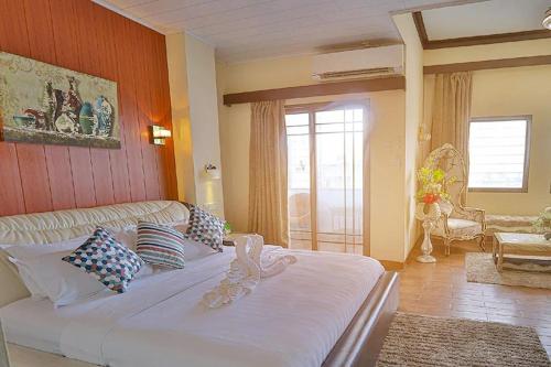 ein Schlafzimmer mit einem großen weißen Bett in einem Zimmer in der Unterkunft Hotel Essencia in Dumaguete