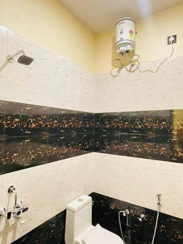 a bathroom with a toilet and a camera on the wall at SR Resort in Milkīpur