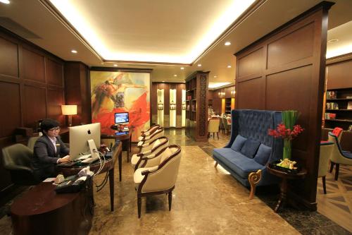 une femme assise à un bureau dans le hall de l'hôtel dans l'établissement The Scarlett Boutique Hotel, à Hue