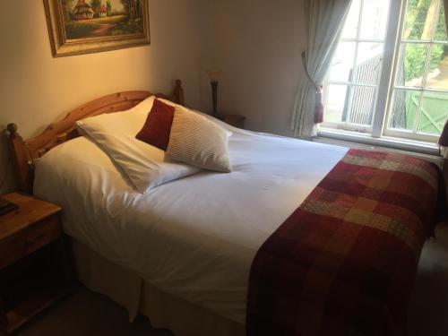 a bedroom with a bed with white sheets and a window at The Winchfield Inn in Winchfield