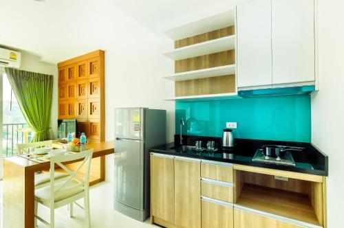 a kitchen with a black counter top and a refrigerator at G Residence in Pattaya South