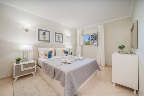 a white bedroom with a large bed and a window at Vila da Praia by ALgest in Alvor
