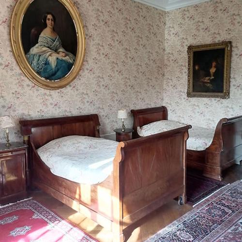 a bedroom with two beds and a mirror on the wall at Manoir de Villers in Saint-Pierre-de-Manneville