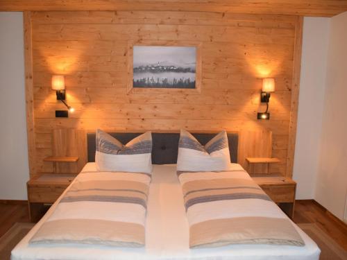 a bedroom with two beds in a wooden wall at Pension Zum Lebzelter in Freyung