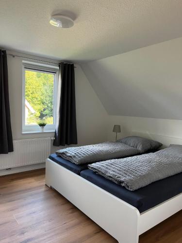 a bedroom with a bed and a window at Ferienhaus Helmshuus in Leer