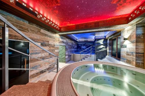 a jacuzzi tub in a room with a red ceiling at Grand Regle Resort & SPA in Poronin