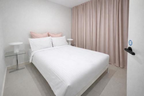 a white bedroom with a large white bed with pink curtains at ProHouse - Sydney Airport Wolli Creek in Sydney