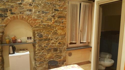 cocina con pared de piedra, encimera y fregadero en Apartment Camere Cinque Terre Andrea, en La Spezia