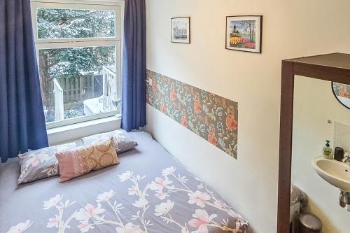 a bedroom with a bed with a window and a sink at B&B West City Amsterdam in Amsterdam