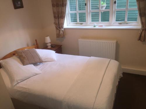 a bedroom with a large white bed with a window at The Winchfield Inn in Winchfield