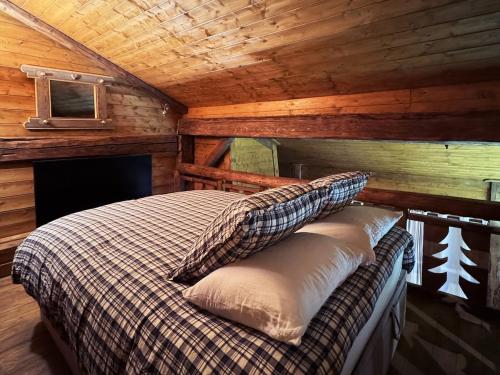a bedroom with a bed in a log cabin at Exceptional Duplex, Cozy & Authentic Atmosphere in Les Gets