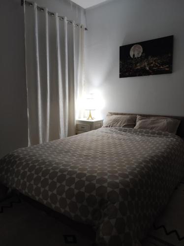 a bedroom with a bed and a window with curtains at Panamera 8 in Sousse