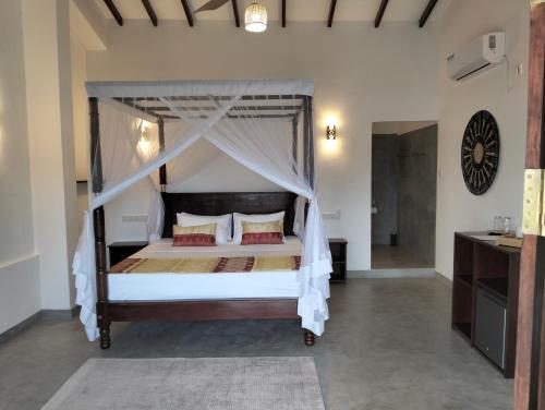 a bedroom with a bed with a canopy at White House Tangalle in Tangalle