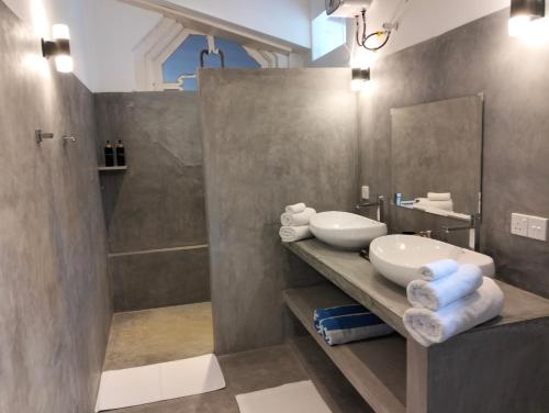 a bathroom with a sink and a shower and a mirror at White House Tangalle in Tangalle