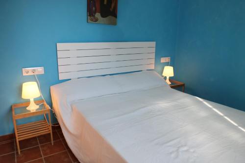 a blue bedroom with a large bed with two lamps at DADA CAÑOS in Los Caños de Meca
