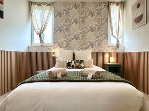 a bedroom with a large bed with two windows at Le Bohème - hyper centre - cosy in Mont-de-Marsan